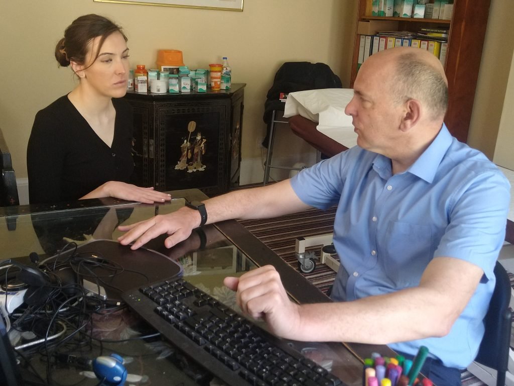 A man and a woman working together at a desk computer.