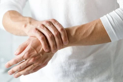 A man experiencing discomfort in his wrist due to finger pain.