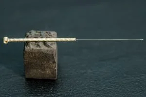 A screw is resting on a wooden block.