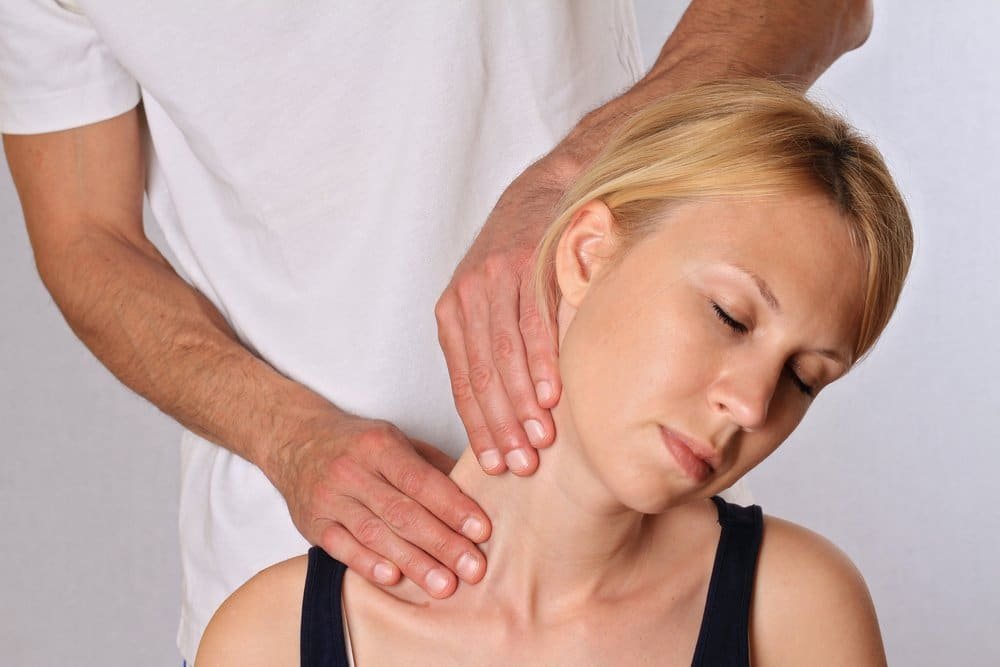 An osteopathy session where a woman receives a neck massage.